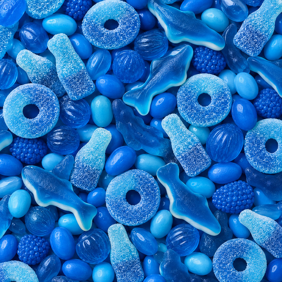 A close-up, top-down view of assorted blue gummy candies, including shark-shaped gummies, ring-shaped gummies, bottle-shaped gummies, and blue jelly beans.