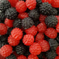 A vibrant collection of black and red berry shaped gummy lollies in blackberry and raspberry flavors