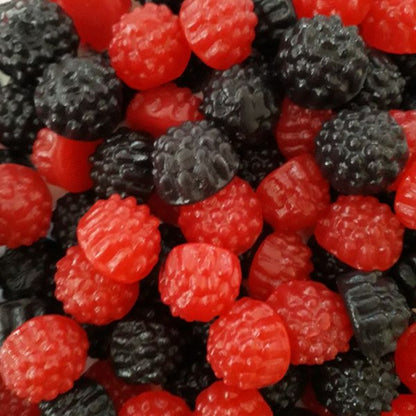A vibrant collection of black and red berry shaped gummy lollies in blackberry and raspberry flavors