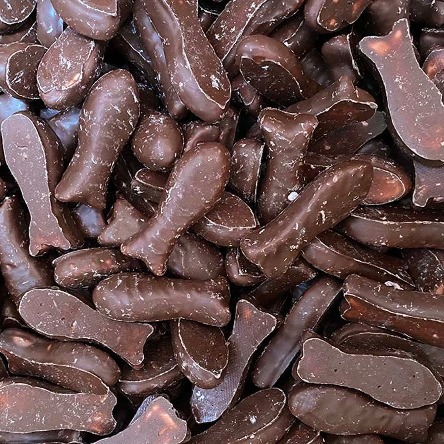 A pile of classic bite sized raspberry chewy fish lollies coated in a smooth milk chocolate layer
