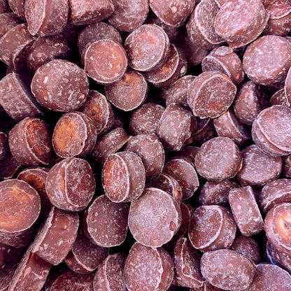 A pile of classic bite sized square chewy caramel centers covered in a smooth milk chocolate coating