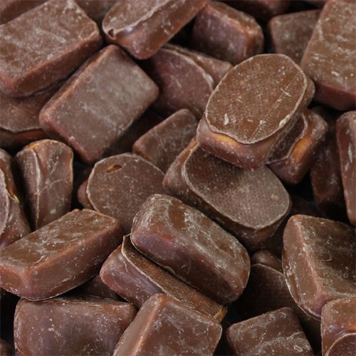 A pile of classic bite sized yellow pineapple flavored chewy centers covered in a smooth milk chocolate coating