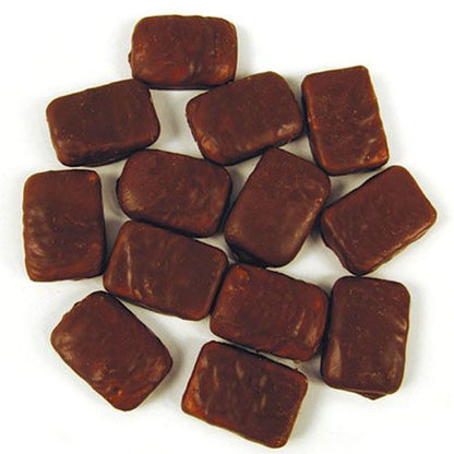 Pile of classic bite sized yellow pineapple flavored chewy centers covered in a smooth milk chocolate coating