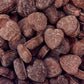 A pile of red strawberry flavored chew heart lollies coated in smooth milk chocolate