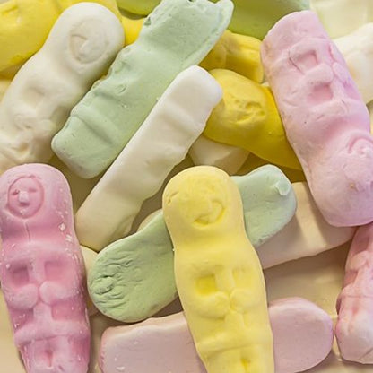 A colorful assortment of eskimo shaped grained marshmallow emo lollies in yellow pink and green