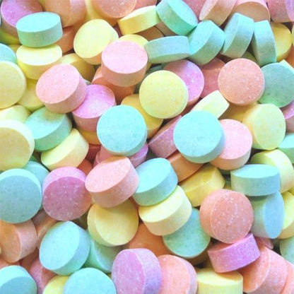 An assortment of colorful round fizzy tablet lollies in orange, raspberry, lime, and pineapple flavors