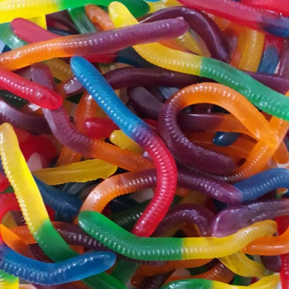 A vibrant pile of multi colored neon worm shaped gummy lollies in mixed fruit flavors