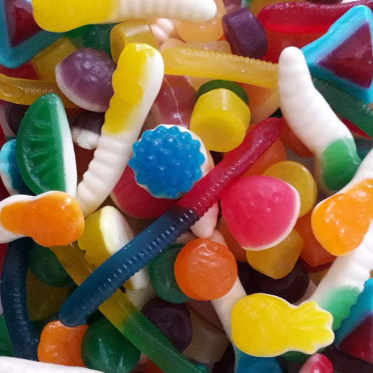 A vibrant assortment of various colorful gummy lolly shapes and fruit flavors mixed together