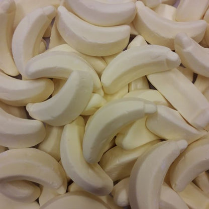 A pile of yellow banana shaped grained marshmallow kandy banana lollies