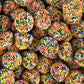 A pile of dome shaped licorice flavored jelly lollies completely coated in colorful hundreds and thousands sprinkles