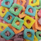 A colorful mix of Rainbow Sour Squares featuring vibrant, square-shaped aerated gummy lollies coated in a fine dusting of sour powder.